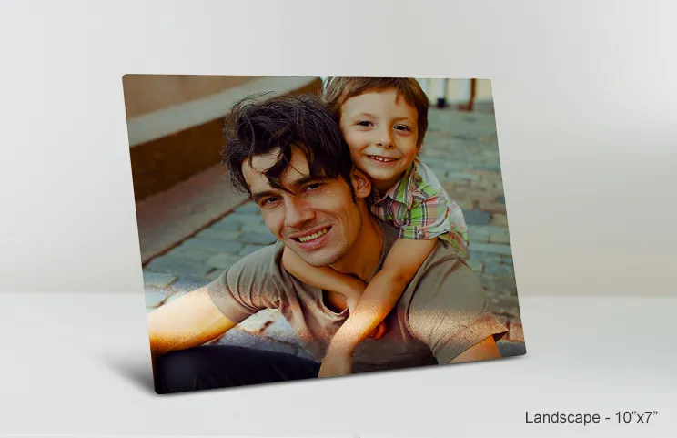Metalen fotoprint van Printerpix|Aluminium fotoprint van een berg en een meer vastgehouden door een vrouw gemaakt door Printerpix|Kleine vierkante metalen print van een man die in een meer duikt|Metalen fotoprint van moeder en dochter op boekenplank|Vrouw plaatst metalen print van vriendin en vriend op muur|Drie metalen fotoprints van verschillende maten|||||