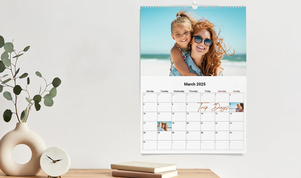 Gepersonaliseerde wandkalender 2020 van Printerpix|Gepersonaliseerde Fotokalenders|Vrouw schrijft op A4 gepersonaliseerde wandkalender van printerpix met kerstthema foto|A3 2020 wandkalender opgehangen met gepersonaliseerd fotodesign van printerpix|Romantisch stel in woonkamer met gepersonaliseerde 2020 wandkalender met aanzoekfoto|Hondenfoto's op op maat gemaakte fotokalender aan de muur gehangen