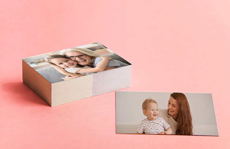 Kleine, middelgrote en grote fotoafdrukken op tafel vanaf mobiele telefoon