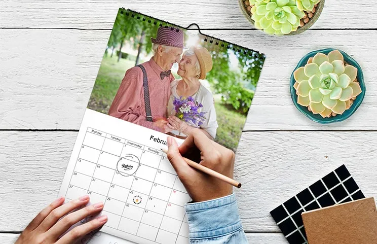 Vrouw schrijft op A4 gepersonaliseerde wandkalender van printerpix met kerstthemafoto