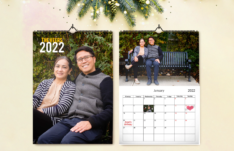 Vrouw schrijft op A4 gepersonaliseerde wandkalender van printerpix met kerstthemafoto
