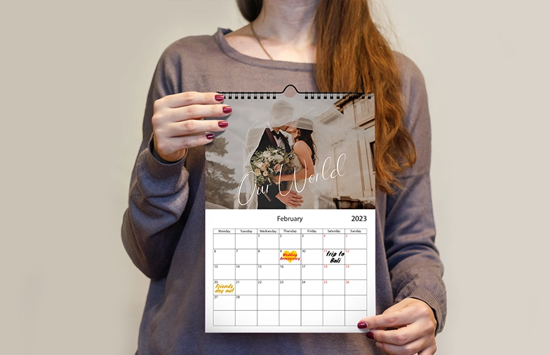 Vrouw schrijft op A4 gepersonaliseerde wandkalender van printerpix met kerstthemafoto