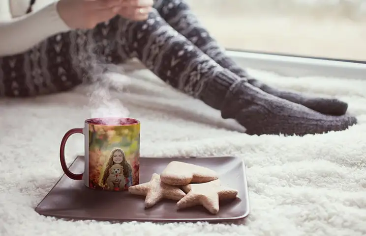 Gepersonaliseerde rode mok met foto van jong meisje naast koekjes