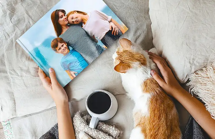 Huisdier en vrouw kijken naar gepersonaliseerd familie-fotoboek met aangepast ontwerp