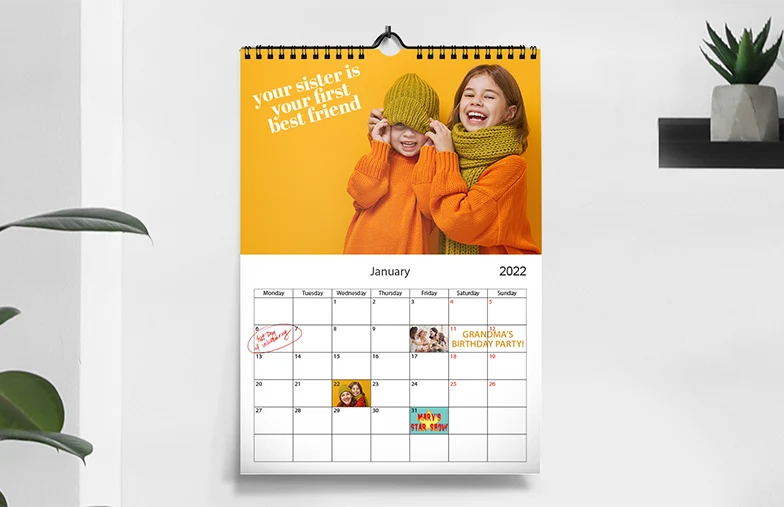 Romantisch stel in de woonkamer met gepersonaliseerde 2020 wandkalender met aanzoekfoto