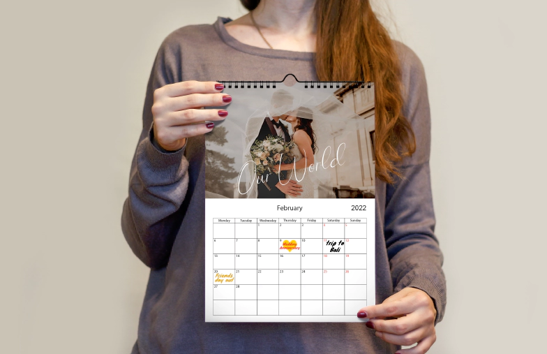 Romantisch stel in woonkamer met gepersonaliseerde 2020 wandkalender met voorstel foto