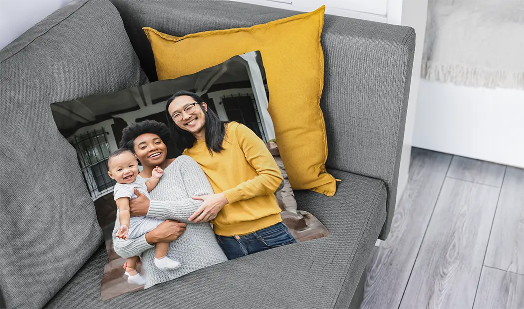 Gepersonaliseerd kussen met een gelukkige familiefoto, geplaatst op een bank. Maak een uniek aandenken!