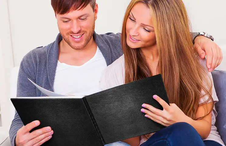 Koppel bekijkt leren omslag op maat gemaakt fotoboek gemaakt door Printerpix