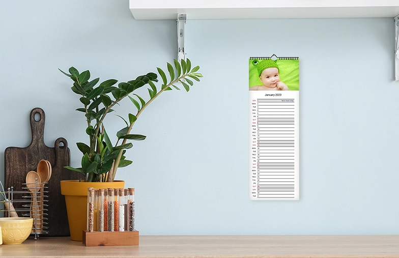 Romantisch stel in de woonkamer met gepersonaliseerde 2020 wandkalender met aanzoekfoto
