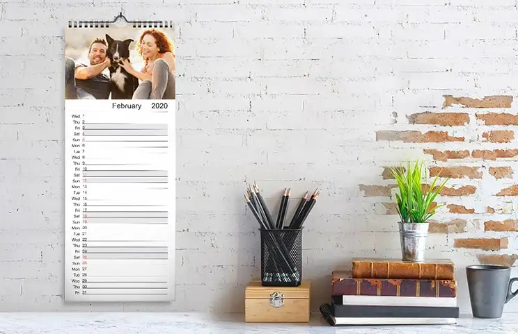 Vrouw kijkt naar gepersonaliseerde kalender met foto van hond gemaakt op mobiel